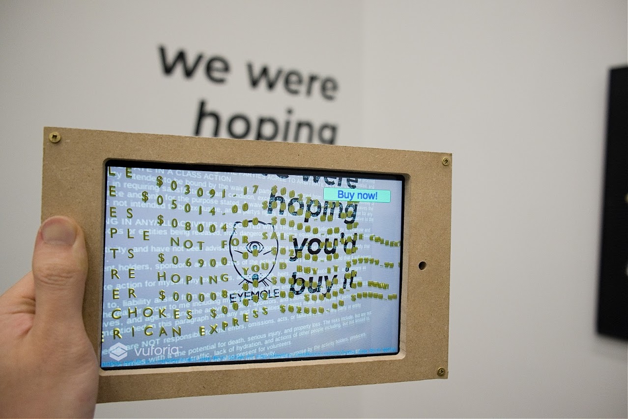 A tablet displaying a list of golden price tags on top of a painting